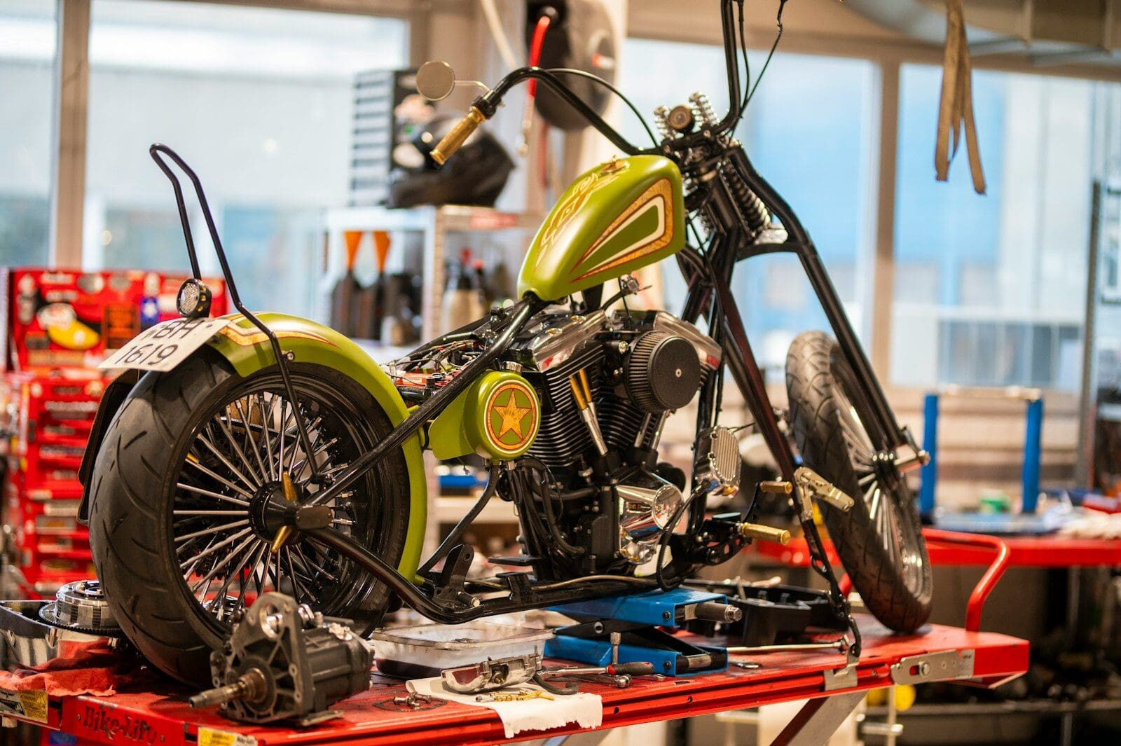 A custom green motorcycle being assembled in a workshop